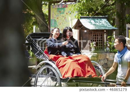 停止在旅遊信息地圖前面的人力車的兩個高中女孩 46865279