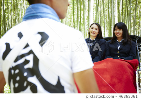 Two high school girls riding a rickshaw in a bamboo forest 46865361