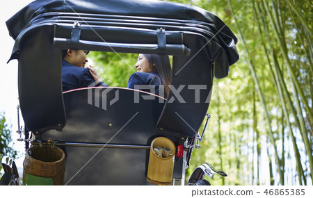 乘坐人力車的兩個高中女孩在一個竹森林裡 乘坐人力車的兩個高中女孩在一個竹森林裡 46865385