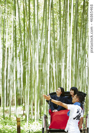 Two high school girls riding a rickshaw in a bamboo forest 46865468