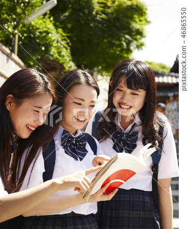 在手中走在城市的三個高中女孩與指南 46865550