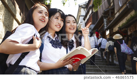 在手中走在城市的三個高中女孩與指南 46865575