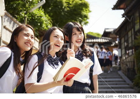在手中走在城市的三個高中女孩與指南 46865576