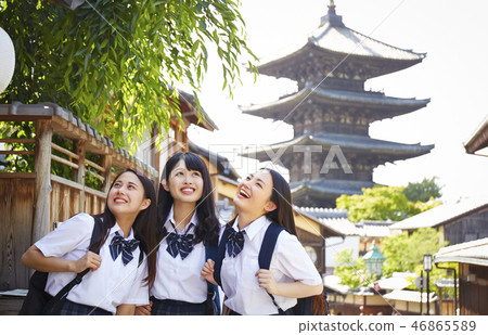 Three high school girls standing against five-story pagoda 46865589