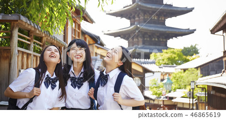 Three high school girls standing against five-story pagoda Three high school girls standing against five-story pagoda 46865619