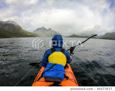 Photo from back of tourist with paddle on canoe floating 46873637