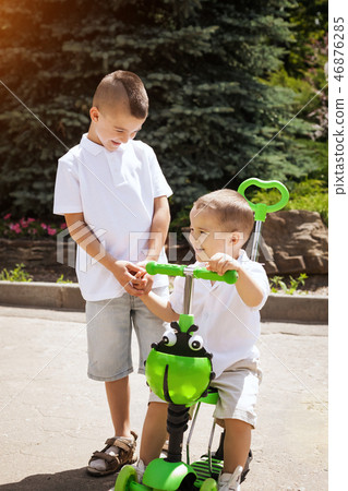 boy with brother near a trike 46876285