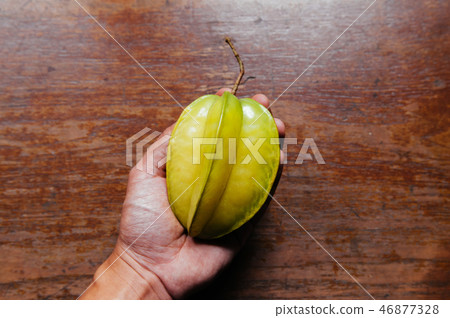 Star fruit carambola in a hand wooden background 46877328