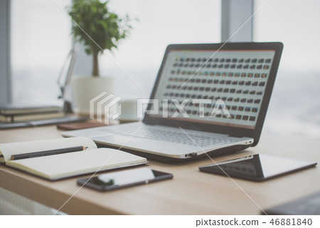 Workplace with notebook laptop Comfortable work table in office windows and city view. Workplace with notebook laptop Comfortable work table in office windows and city view. 46881840