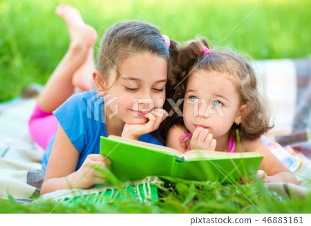 Two little girls are reading book 46883161