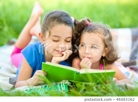 Two little girls are reading book Two little girls are reading book 46883162