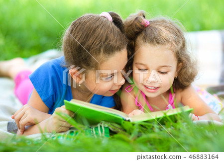 Two little girls are reading book 46883164