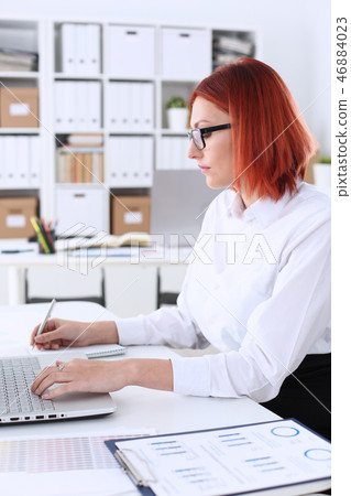 Business woman redhead office portrait sit table Business woman redhead office portrait sit table 46884023