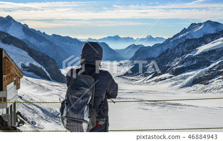 A man with backpack enjoying on snow peak A man with backpack enjoying on snow peak 46884943