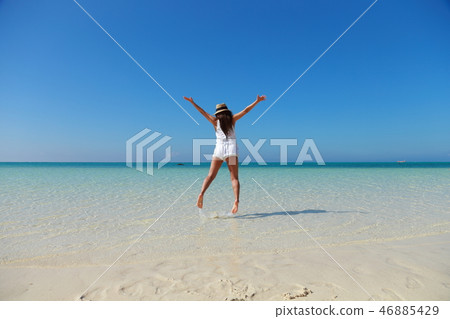後面觀點的跳躍在美麗的海的婦女 後面觀點的跳躍在美麗的海的婦女 46885429