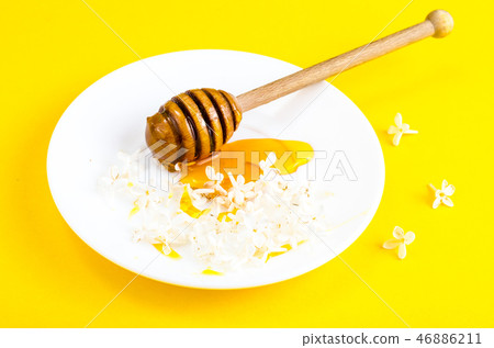 Plate with honey and spoon on yellow background Plate with honey and spoon on yellow background 46886211