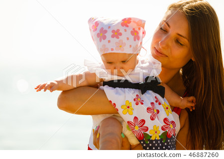 Mother playing with baby on beach Mother playing with baby on beach 46887260