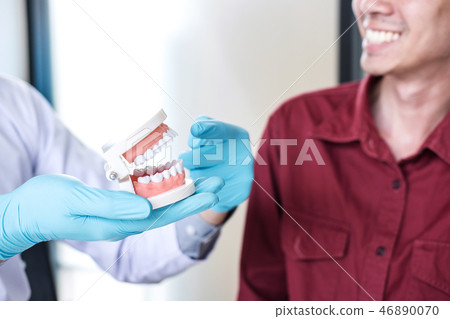 Male doctor or dentist working with jaw model and recommend pati 46890070
