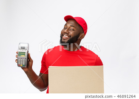 Happy young African American delivery man holding up an electronic card payment machine and delivery Happy young African American delivery man holding up an electronic card payment machine and delivery 46891264