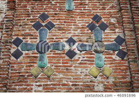 Ancient brick wall decorated with majolica tiles. 46891696