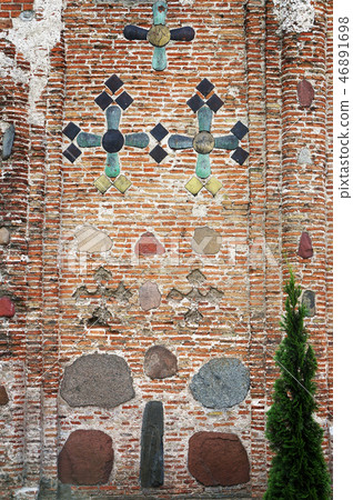 Ancient brick wall decorated with majolica tiles. 46891698