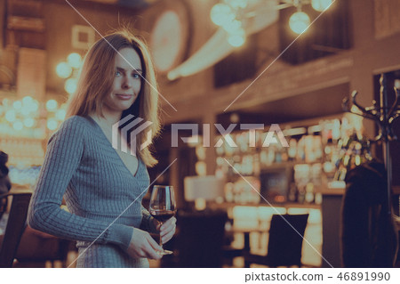 girl with glass of red wine in her hand in a bar girl with glass of red wine in her hand in a bar 46891990