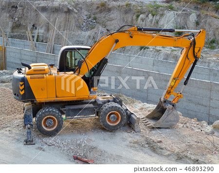 Yellow excavator in the construction pit 46893290
