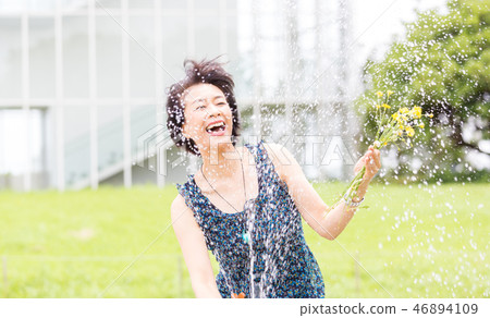 Pretty arafif woman playing with water in the park Pretty arafif woman playing with water in the park 46894109