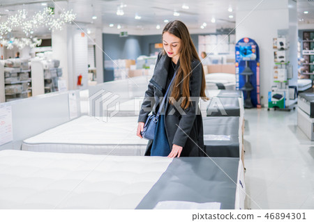 Customer woman buying new furniture - bed in a store 46894301