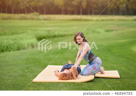 Two women perfoming thai massage. 46894785