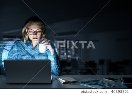 Beautiful blonde in dark office working on laptop and getting ne Beautiful blonde in dark office working on laptop and getting ne 46898801