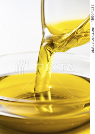 Pour olive oil into the bowl Pour olive oil into the bowl 46904188