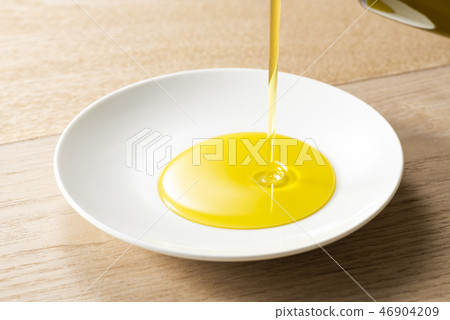 Pour olive oil into the bowl Pour olive oil into the bowl 46904209
