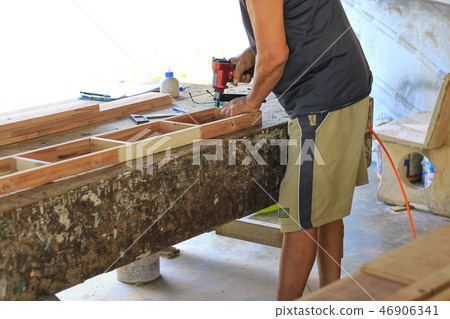 Carpenters are using tools with wood . 46906341