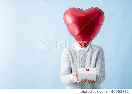 Heart shaped face woman holding a present 46908812