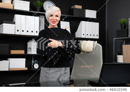 young girl stands near computer Desk in a stylish business office 46910390