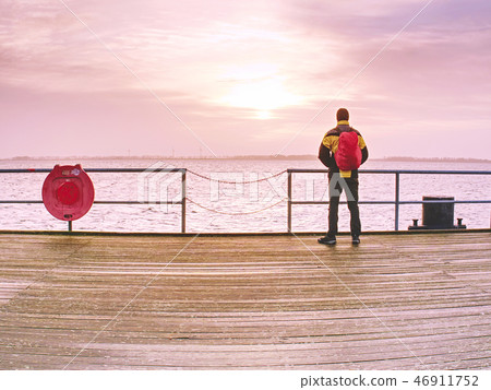 Man in trekking suit in harbor in daybreak. 46911752
