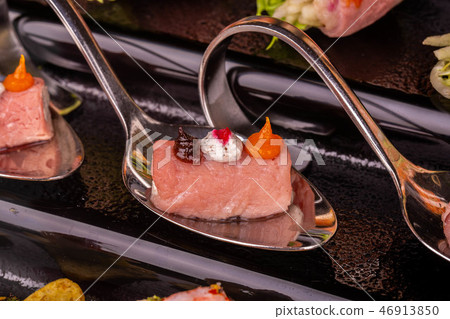 Meat rolls with cream and mousse on a black suppor Meat rolls with cream and mousse on a black suppor 46913850