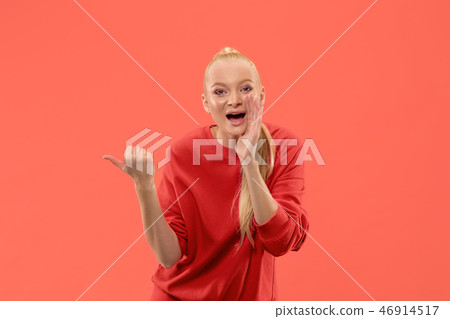 Isolated on coral young casual woman shouting at studio 46914517