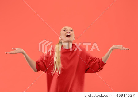 The happy business woman standing and smiling against coral background. The happy business woman standing and smiling against coral background. 46914527