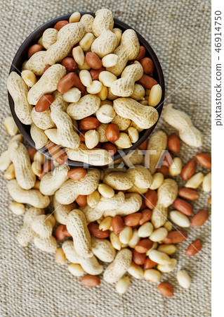 Peanuts in the shell and peeled close-up in cups. Roasted peanuts in their shells and peeled against Peanuts in the shell and peeled close-up in cups. Roasted peanuts in their shells and peeled against 46914750