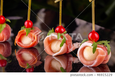 The cheese wrapped in bacon with red currant The cheese wrapped in bacon with red currant 46915229