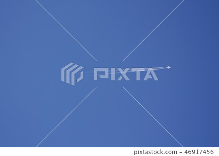 White shining Boeing 787 airliner flying in the blue sky while drawing contrails White shining Boeing 787 airliner flying in the blue sky while drawing contrails 46917456
