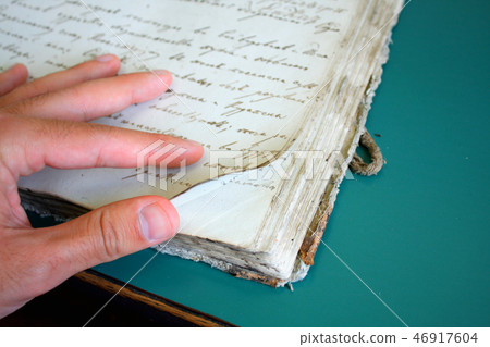 man showing very old book pages man showing very old book pages 46917604