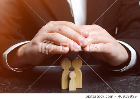 Insurance agent holds hands over family.  46919959