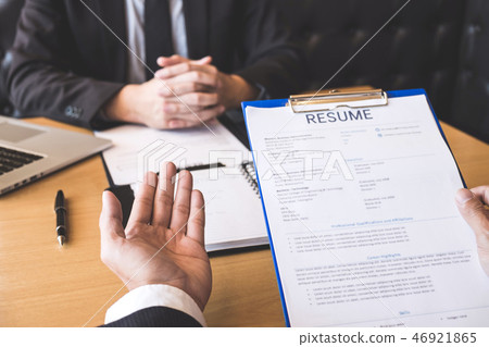 Employer or recruiter holding reading a resume during about his 46921865