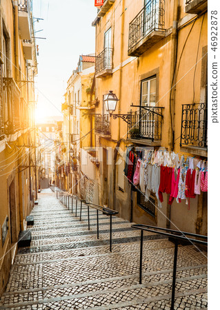 Staircase in the cobblestone street in Lisbon. Hanging laundry in typical narrow street. Sunset in 46922878