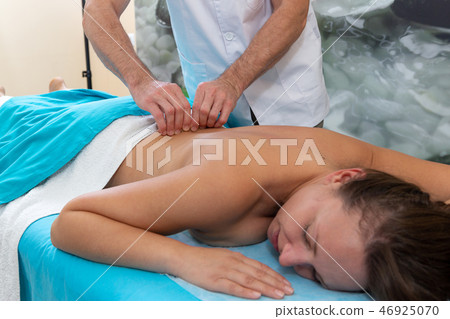 Osteopath massages the patient on her back. Tightening the skin. Osteopath massages the patient on her back. Tightening the skin. 46925070