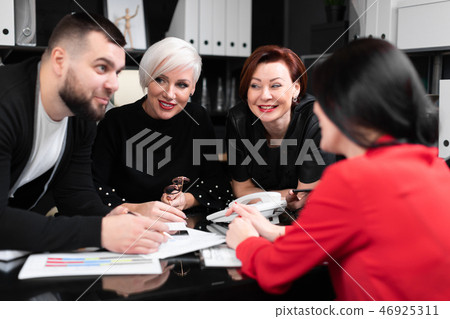 Smiling employees talking in workplace 46925311