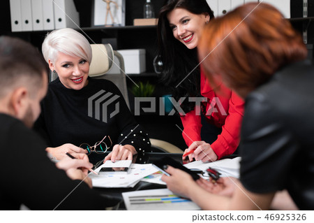 Smiling employees talking in workplace Smiling employees talking in workplace 46925326